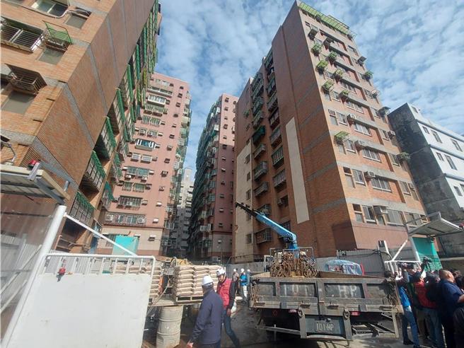 新北市三重区新建案工地「玖长匯比寿」27日开挖地下室时，因涌水导致附近建筑倾斜，已疏散近百位居民。（张铠乙摄）