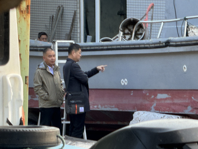 圖為泉州台辦副主任李朝暉（左）與晉江紅十字會秘書長曹榮山（右）仔細觀察翻覆漁船之外觀，查看有無可疑之處。（資料照／于家麒攝）