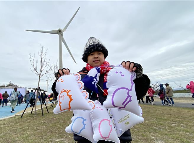 彰化县伸港乡嬉滨海豚公园2日举办启用典礼遇寒流来袭，民眾冒冷风在清晨5时许抢手炙手可热的「多多龙」小提灯，就读国小三年级的陈姓小朋友收齐陆续推出绿、蓝、粉红、橘及紫等5顏色小提灯，民眾称他为「多多龙小富翁」，兴奋要求合照。（陈淑芬摄）