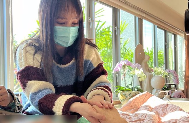 小薰为心莲病房的癌末患者手部精油按摩。（大爱提供）