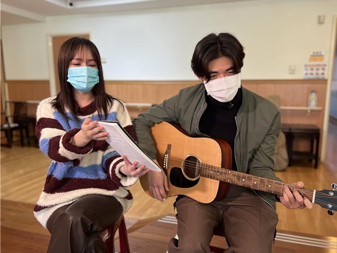 梁正群（又）备吉他自弹自唱、小薰帮忙拿谱。（大爱提供）