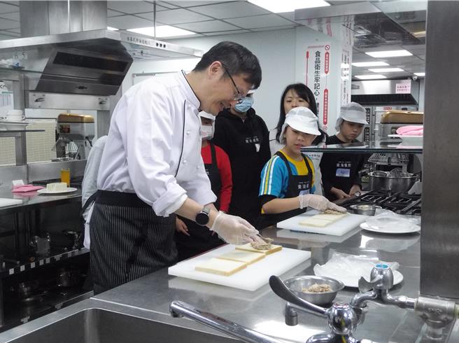 新北教育局长张明文（左）首次与小选手一同切磋术科题目「鲔鱼三明治」。（张铠乙摄）