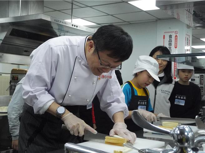 新北教育局长张明文（左）首次与小选手一同切磋术科题目「鲔鱼三明治」。（张铠乙摄）