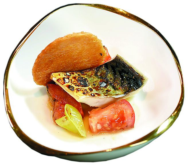 〈鱼片米粉〉是以炭烤鲭鱼搭配火烤玉女番茄、麵线，再加入用鸡、猪、鱼骨熬制的底汤，与炼奶、大量蔬菜煮成的浓汤一起享用。图／姚舜