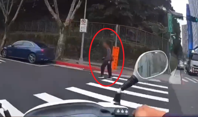 林男（紅圈）違規穿越車道被警方活逮，包包被搜出針筒，竟然瞎掰「阿嬤打胰島素要用的」。（翻攝畫面）