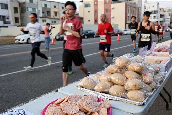 台南古都国际半程马拉松设有美食小吃大道，提供烤鸡、猪脚、蜂蜜滷味及现打果汁等多样特色美食小吃，让跑友跑累了可以吃美食。（市府提供／洪荣志台南传真）