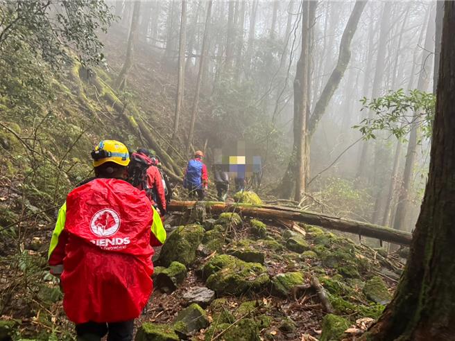 嘉义县警消人员组成搜救队寻获女登山客遗体后轮流背运送。（嘉义县消防局提供／廖素慧嘉县传真）