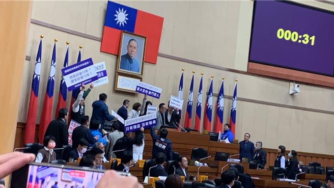 基隆东岸广场争议持续延烧，今日基隆市议会召开临时会，轮到民进党议员曾怡芳发言时，民进党议员举牌欲至市长谢国梁（台上后排左三）旁发言，蓝绿议员爆发衝突。（徐佑升摄）