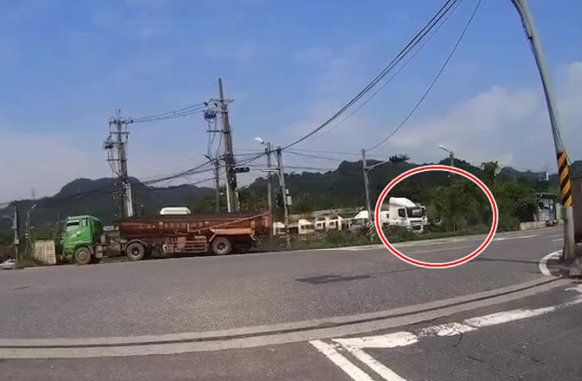 警方調閱監視器，發現上午11時24分許，一輛大貨車由五堵交流道往汐止方向，因不明原因輪胎脫落，砸傷實踐路253巷貨運公司內除草中46歲阮姓員工。（翻攝畫面）