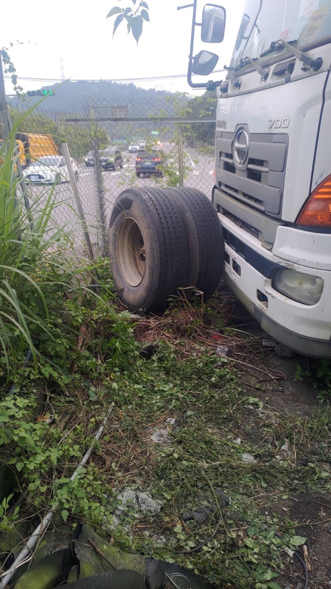 警方調閱監視器，發現上午11時24分許，一輛大貨車由五堵交流道往汐止方向，因不明原因輪胎脫落，砸傷實踐路253巷貨運公司內除草中46歲阮姓員工。（翻攝畫面）