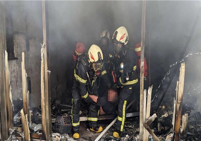 彰化市彰水路1栋5楼透天厝5日上午发生大火，消防员衝入火场救出两位受困民眾。（民眾提供／孙英哲彰化传真）