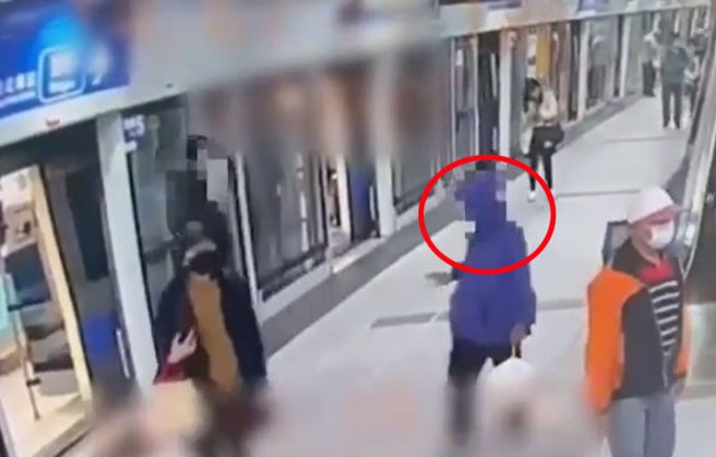 画面显示一名男子身着连帽外套、拿着宝特瓶在女子背后喷洒液体。(撷取自影片)