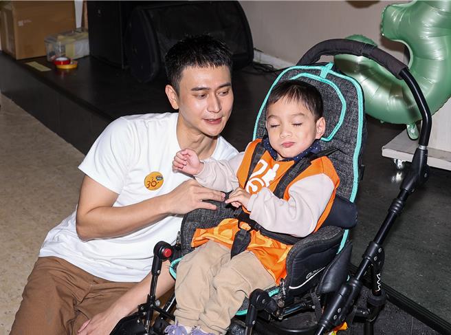 劉冠廷（左）和慢飛天使互動。（羅永銘攝）