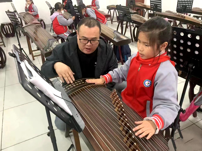 譚家明（左一）正在教學生彈古箏。譚家明供圖