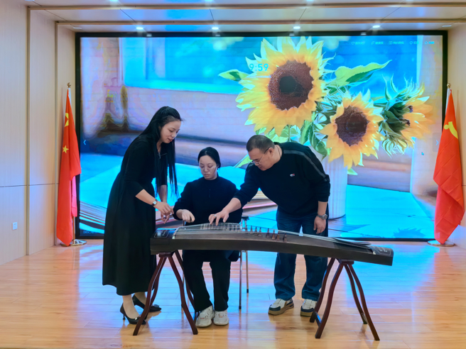 2023年12月13日，譚家明（右一）正在福州市鼓樓區建華社區教學生彈古箏。余劍峰攝