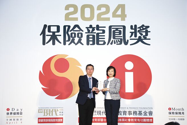 合庫金控總經理陳美足（右）代表接受保險局副局長蔡火炎（左）頒贈「保險龍鳳獎」獎盃。圖／合庫提供