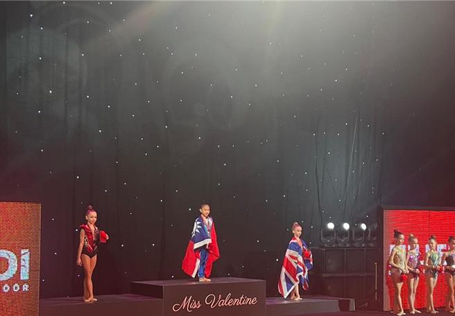 武漢國小羅欣如奪下金牌，披國旗站上頒獎台。（瑞星韻律體操協會提供）