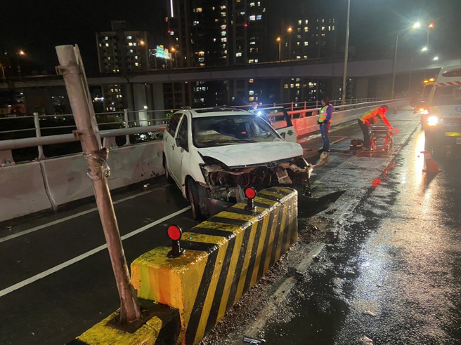 53岁驾驶疑似天雨路滑，不明原因自撞桥上水泥分隔岛，驾驶一度受困车上。 （翻摄画面）