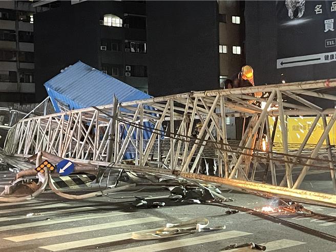 台南天坑案吊臂橫阻馬路，市府加強切割吊臂，爭取７日早上6點前搶通道路。（寶智華攝）