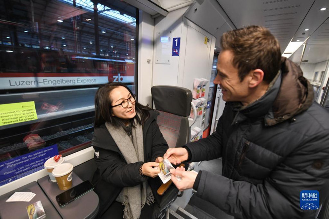 大陆游行团去年已经恢復出团瑞士，为促进欧洲人士访陆，大陆3月14日起对瑞士等欧洲6国试行免签政策。图为去年2月，瑞士中部铁路公司工作人员（右）为中国游客发巧克力。（新华网）