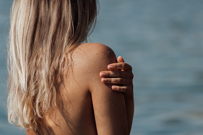 國外正妹在沙灘上曬日光浴，慘遇大叔強行非禮合照。(圖:shutterstock/達志)