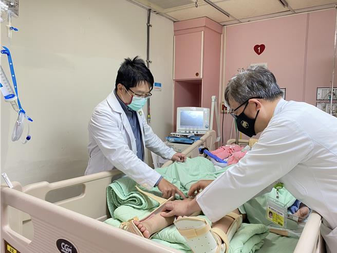 陳姓姊姊在彰化市秀傳醫院搶救，該院神經外科醫師辛明泰（左）測試其腳部反射反應。（院方提供／孫英哲彰化傳真）