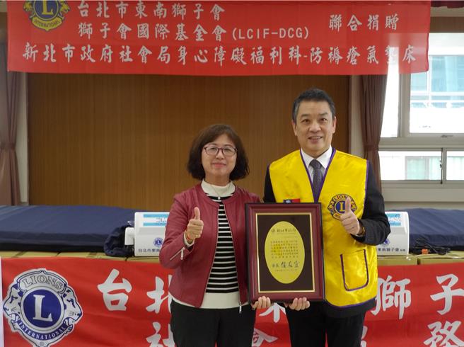 新北市社会局副局长许秀能（左）代表受赠并致赠感谢奖牌，感谢台北市东南狮子会的善心义举。（张铠乙摄）