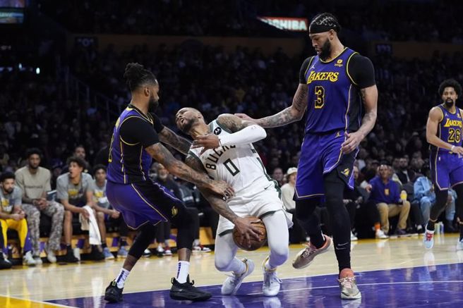 公鹿后卫利拉德(中)被湖人罗素、戴维斯包夹。（美联社）