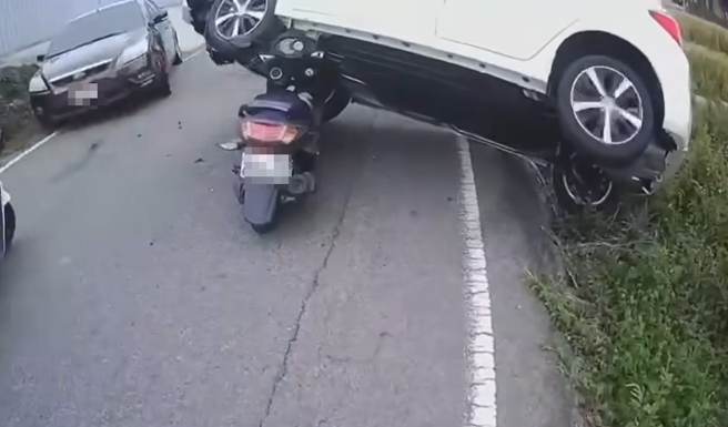 有驾驶在乡间道路发生擦撞车祸，正当要掉进田里时，竟被后方的追撞机车「扛住」了。（图／翻摄自脸书爆废1公社）