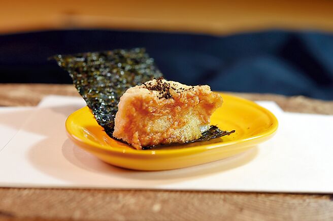 〈干贝矶边扬〉第二吃是裹上厚麵衣，撒焙烤过的黑色七味粉提味，再以海苔包卷入口，风味与口感均富层次。图／姚舜