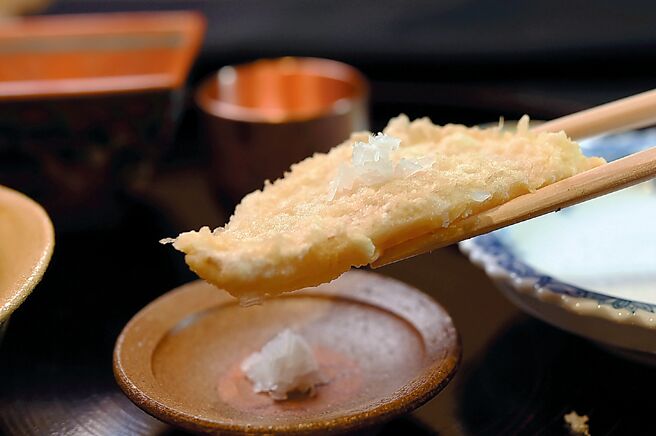 〈小鲷天妇罗〉的鱼肉裹上厚麵衣后低温油炸，确保细致鲜嫩的鱼肉不会被高温破坏，并附蕗荞供客人搭配。图／姚舜