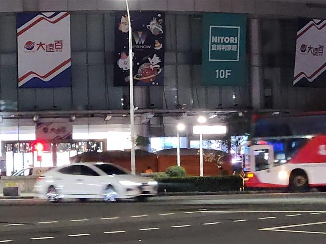 高雄一名男子站在大远百围墙边，警消到场准备大型气垫戒护。（任义宇摄）