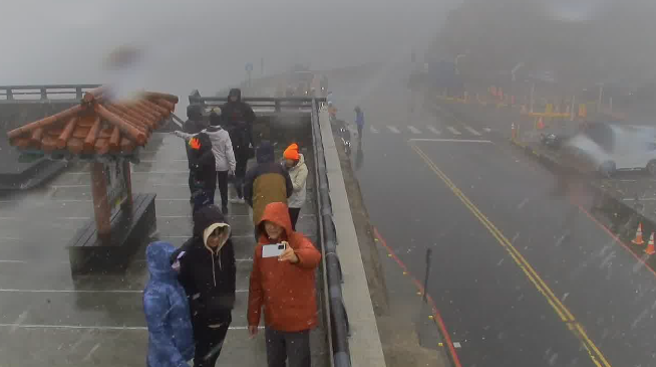 民眾今早在合欢山上兴奋与冰霰、雪花拍照。(翻摄自即时影像)