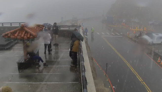 武岭风大降下雪花，民眾差点被风吹走。(翻摄自即时影像)