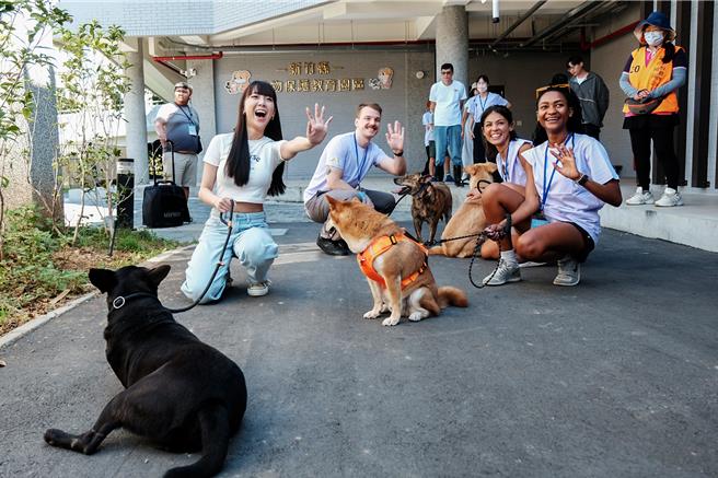 竹縣動保教育園區團體參訪有外籍青年，高興的與園內狗狗互動，學習生命教育。（羅浚濱攝）