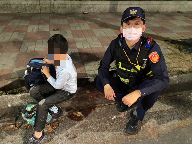 源警到場發現男童無力癱坐路邊，隨後將他背起護送返家。（翻攝畫面）