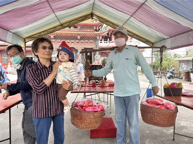 分享添丁之喜，归仁六甲里「担龟」习俗每年都在土地公生日这天举行。(曹婷婷摄)
