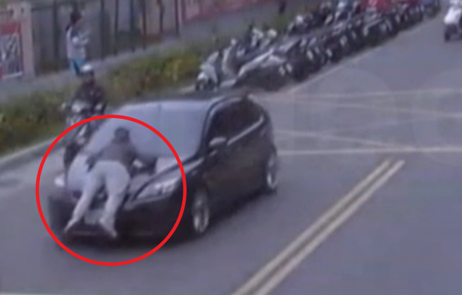 男子趴在行進間車輛的引擎蓋上，警方到場時，他怒檢舉：「車上有毒！」，最後與女友一同送法辦。（翻攝畫面）