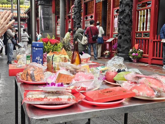 不少信眾准备供品参拜土地公。(游定刚拍摄)
