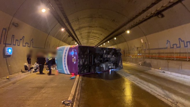 台北市文山区信义快速道路文山隧道往信义区方向1 辆校车翻覆，多名学生轻伤已经逃出在路旁等候。（翻摄画面）