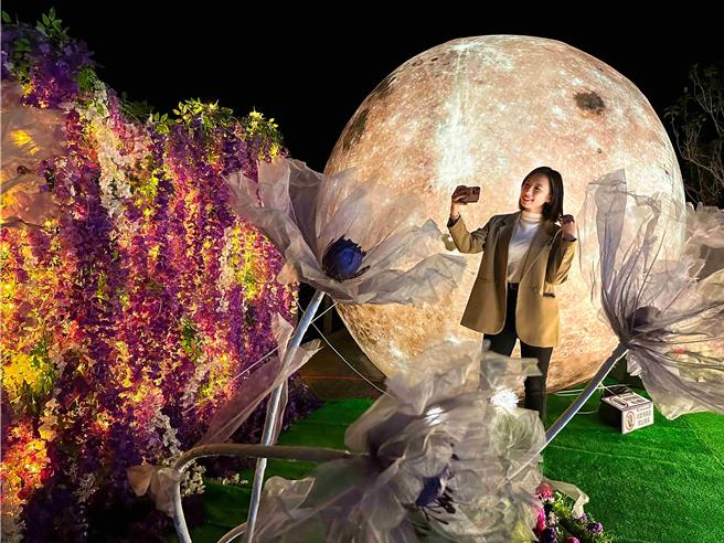 嘉義縣文化觀光局在瑞里源興宮廣場設置的巨型裝置藝術「浪漫紫藤星球」，11日晚上正式點燈亮相，參與來賓迫不及待拍下美照。（嘉義縣政府提供∕呂妍庭嘉義傳真）