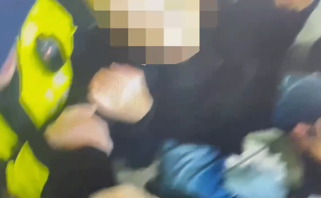 美籍直播主大闹古亭捷运站，诉求反战遭8名员警抬离。(李文正翻摄)