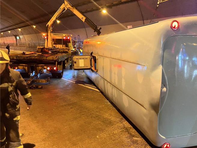 康桥国际学校校车在台北市文山隧道内，疑因地面湿滑，导致车辆翻覆。（翻摄画面）