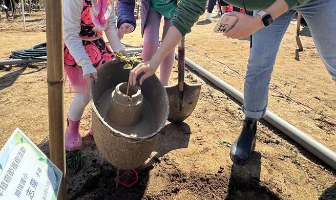 金门植树节活动导入慈心有机农业发展基金会的植树技术以及和泰汽车赞助的水宝盆，藉此来提高树苗的存活率。(于家麒摄)