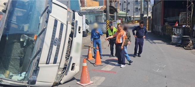 高雄市路竹区成功路223巷口12日出现道路坑洞，一辆水泥预拌车陷落路面。湖内分局长陈桢筌（前）到场视察。（翻摄照片／林瑞益高雄传真）