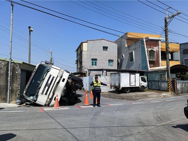 高雄市路竹区成功路223巷口12日出现道路坑洞，一辆水泥预拌车陷落路面，图为事故现场。（翻摄照片／林瑞益高雄传真）