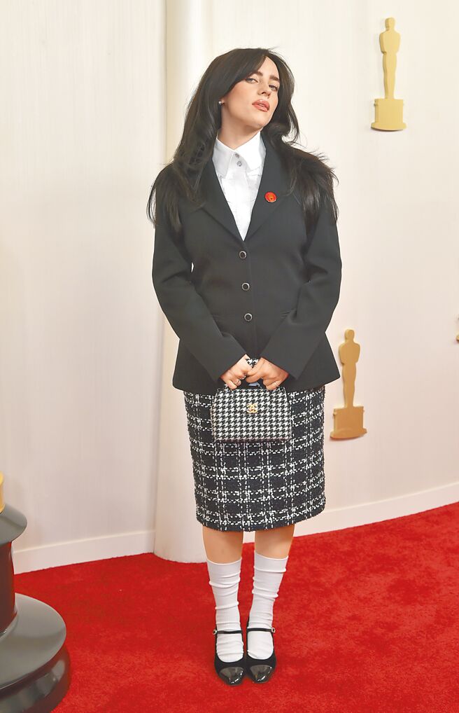 怪奇比莉不按牌理出牌，穿香奈兒套裝假扮學生妹和男星比帥。（美聯社）