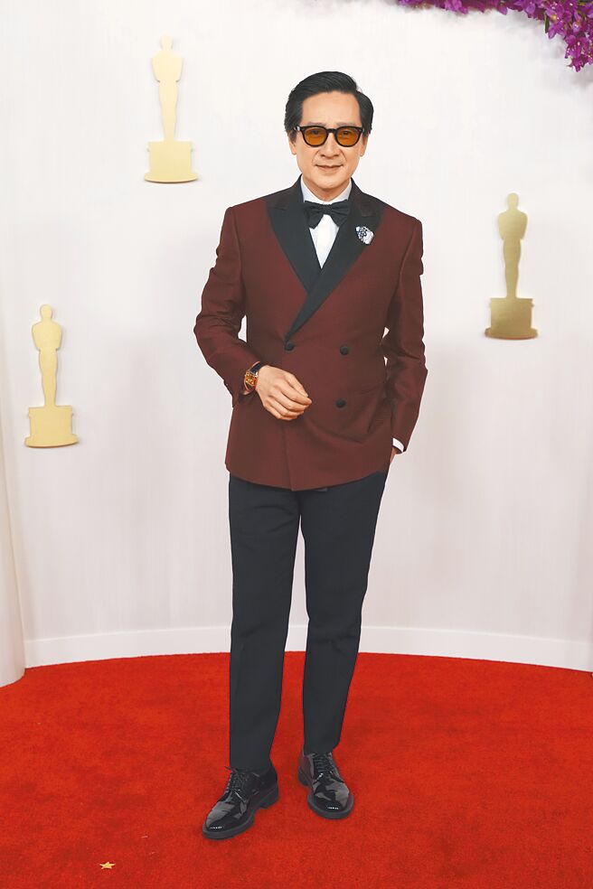 關繼威以暗紅色西裝出席奧斯卡頒獎。（美聯社）