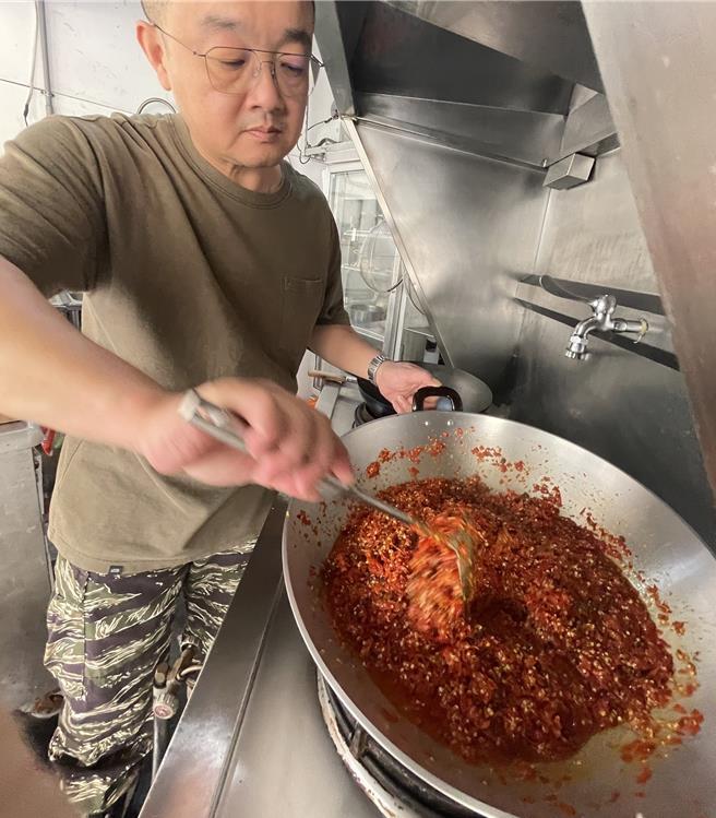 郭峻宾趁店休时间忙着炒辣椒酱。（宝智华摄）