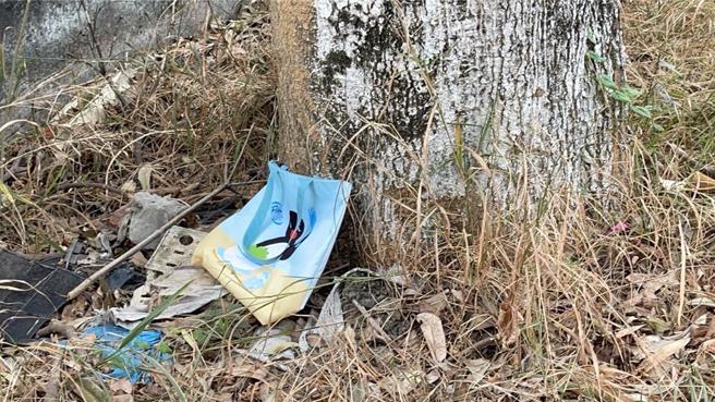 道路对面树底下遗留的袋子，警方要查证是否有无关联。（翻摄照片／洪靖宜高雄传真）